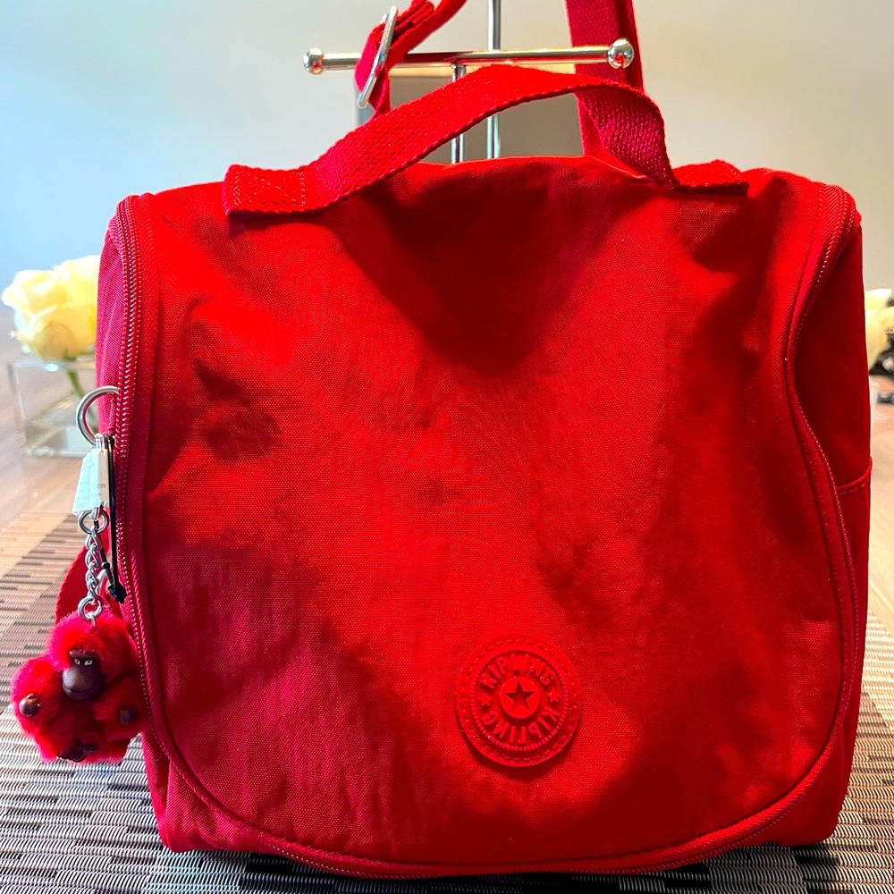 Red Kipling lunch bag with strap.